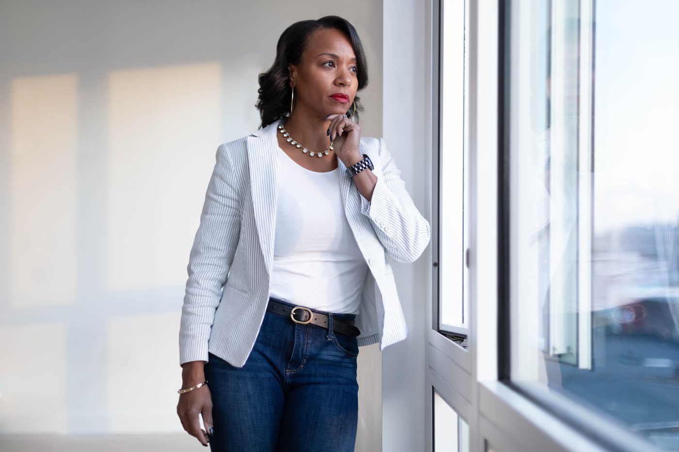 A member of Women of Strength standing in the light of a Charlotte office window